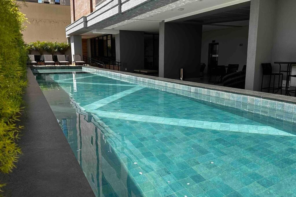 ein großer Pool mit blauen Fliesen in einem Gebäude in der Unterkunft Apartamento 2 quartos, St Bueno Parque Vaca Brava in Goiânia