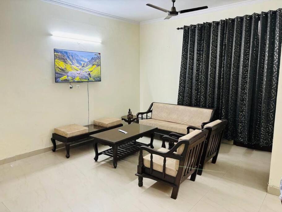 Its a spacious penthouse في شانديغار: غرفة معيشة مع طاولة وكراسي وأريكة
