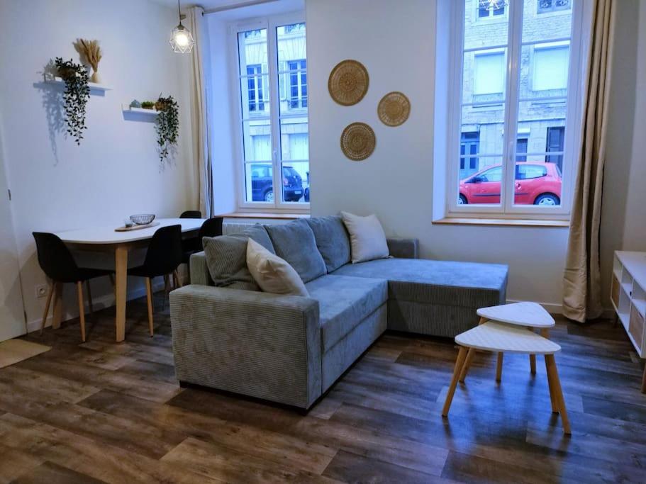 ein Wohnzimmer mit einem Sofa und einem Tisch in der Unterkunft Logement proche Hypercentre CAEN in Caen