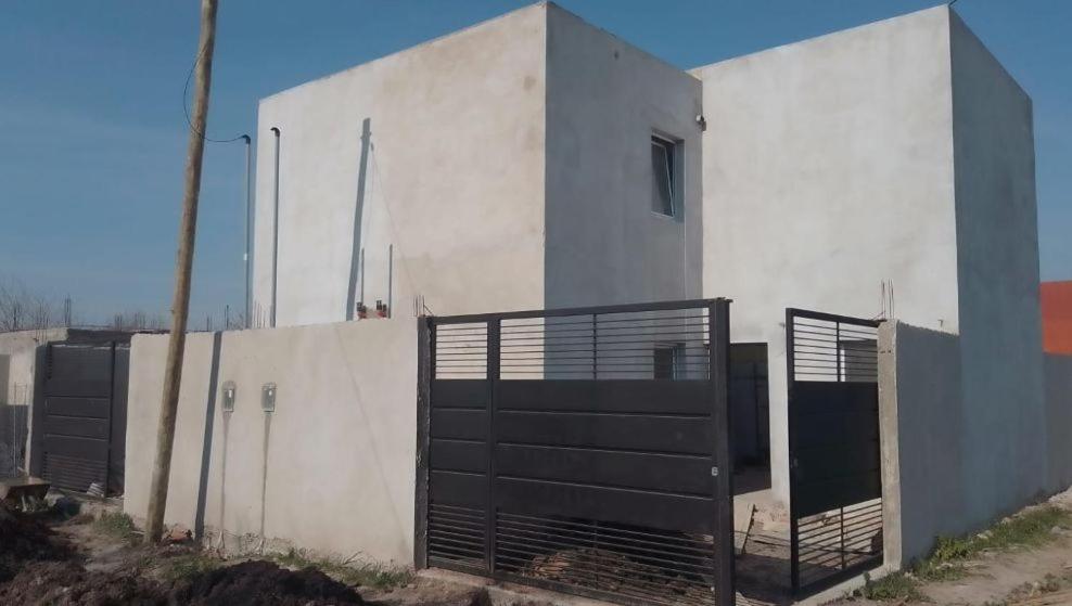 a white building with a gate in front of it at Duplex CATALINA 2 in La Plata