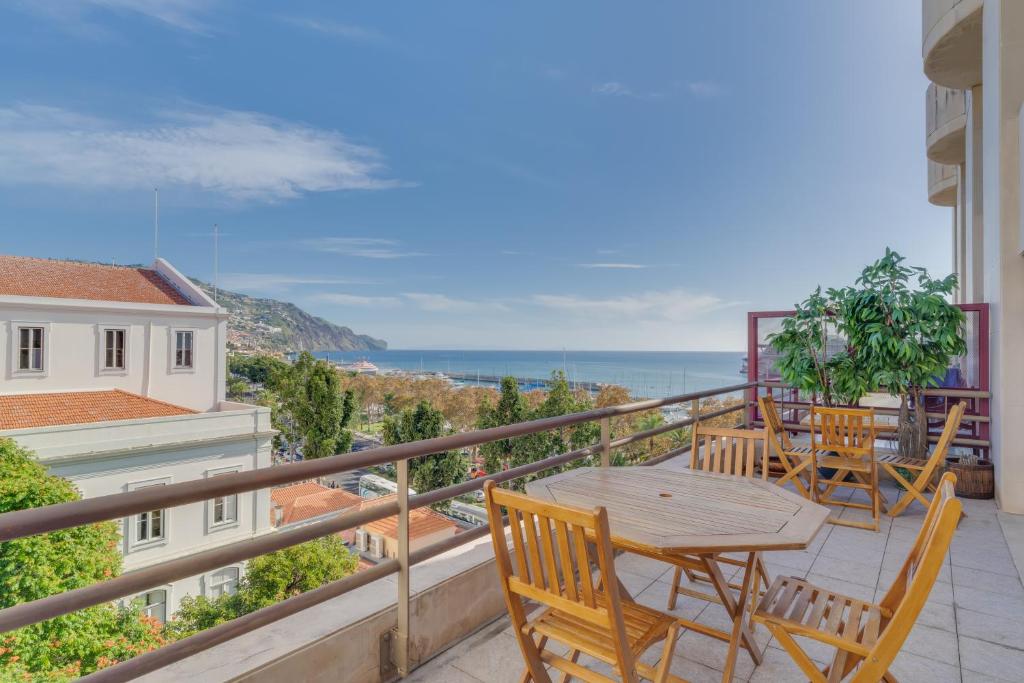 a balcony with a table and chairs and the ocean at avenida arriaga 405 in Funchal