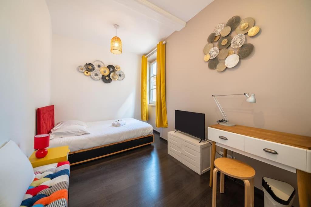 - une petite chambre avec un lit et un bureau avec une chaise dans l'établissement Charmant studio Hyper-centre, à Lyon
