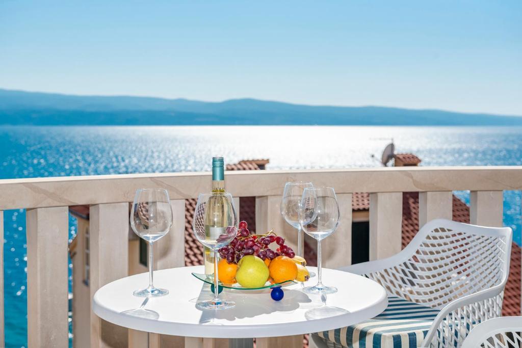 een tafel met wijnglazen en een fruitschaal bij Hotel Villa MiraMar in Omiš