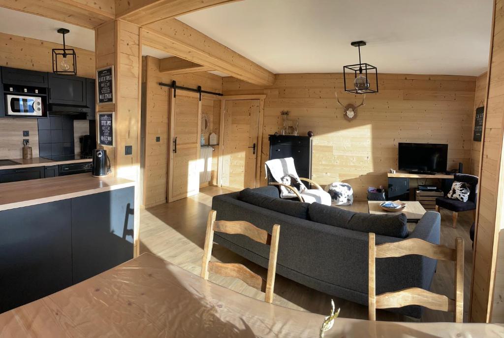 a living room with a couch and a kitchen at LA PERLE DES CAILLOUX EXCEPTIONNEL et COSY in Font Romeu Odeillo Via