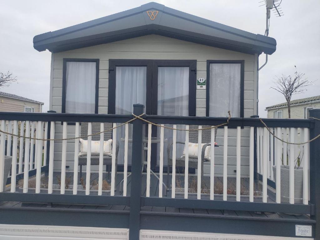 2021 2 bedroom static caravan in 5 stars Patrington haven holiday park في Patrington: منزل صغير على شرفة كرسيين