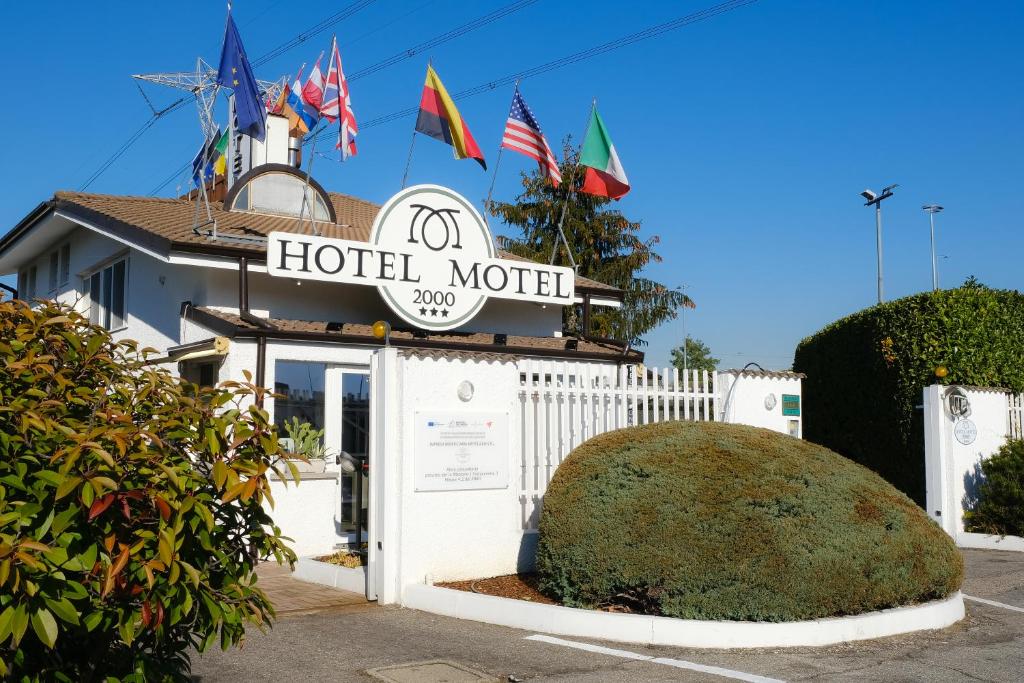 un hotel motel con un cartel y algunas banderas en Hotel Motel 2000 en Trezzano sul Naviglio