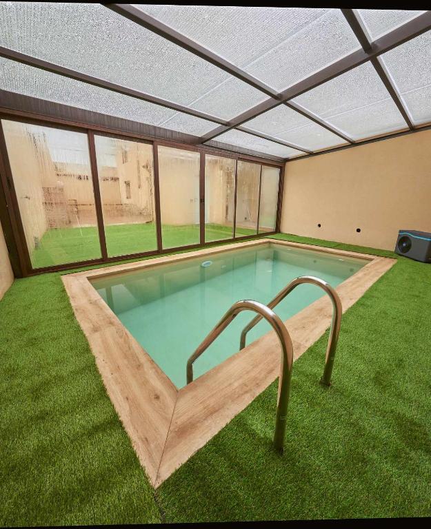 a large swimming pool in the middle of a house at Casa Rural Nueve Villas in Amusco