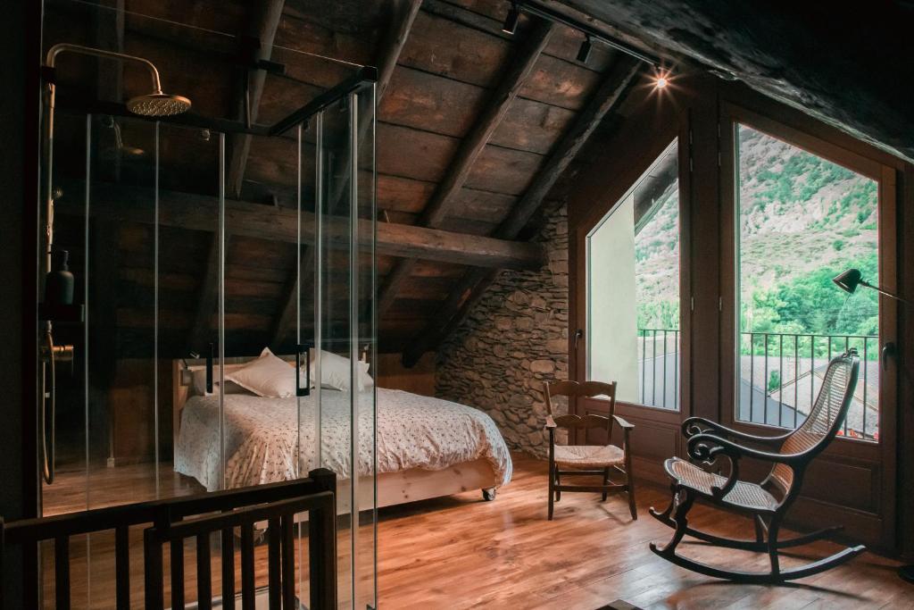 1 dormitorio con 1 cama y pared de cristal en Casa rural Casa Bernat en Isil
