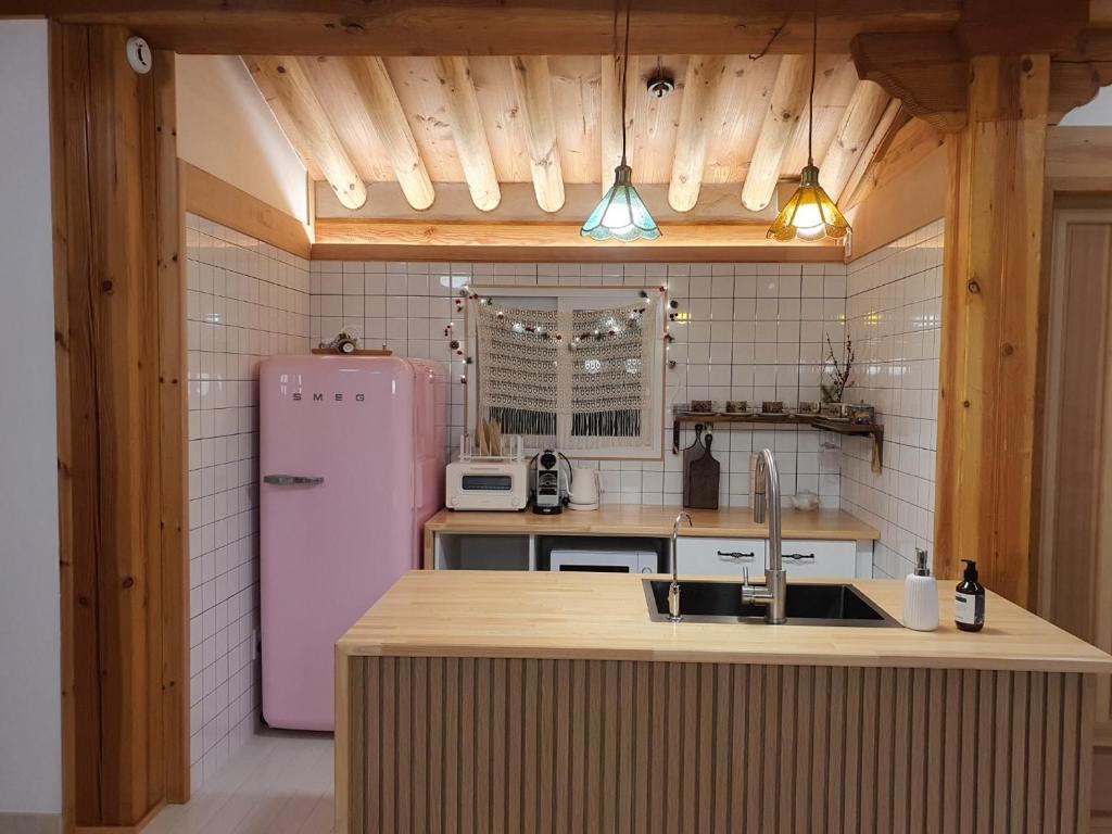 eine Küche mit einem rosa Kühlschrank und einer Spüle in der Unterkunft Haenggung stay Dalno - Suwon private house hanok in Suwon