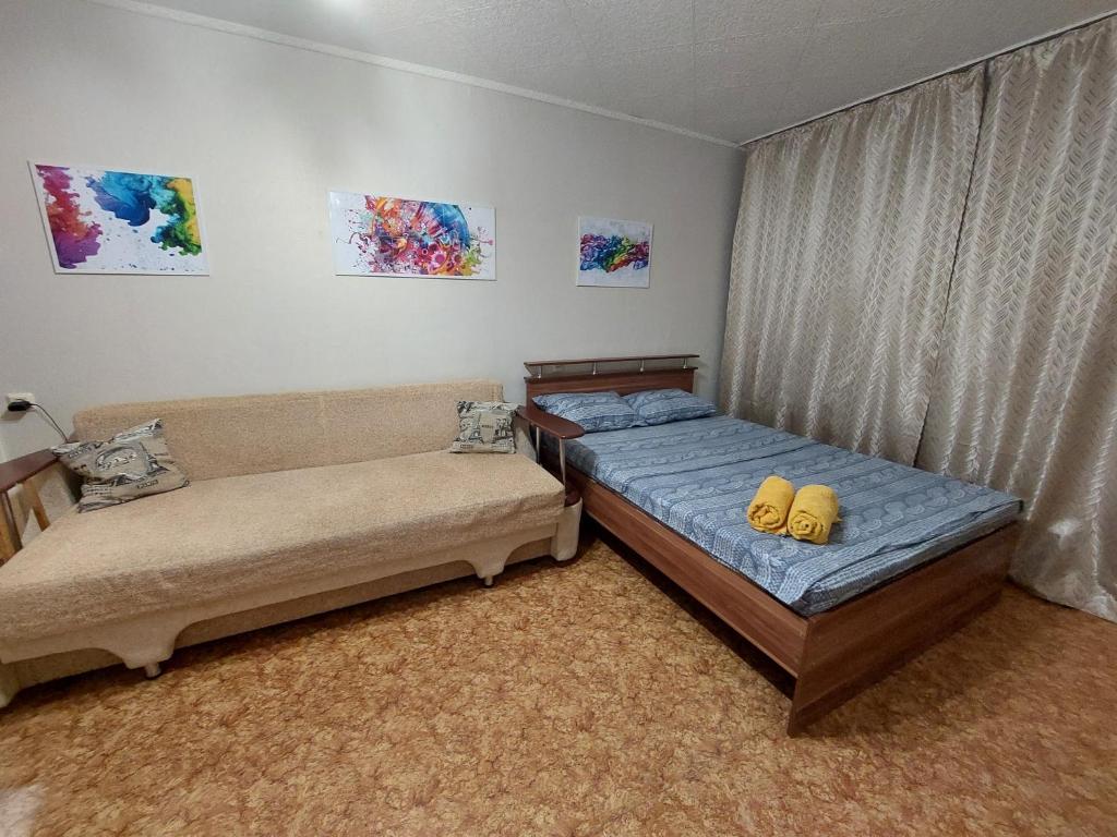 1 Schlafzimmer mit 2 Betten und einem Sofa in der Unterkunft Уютная квартира с удобным расположением in Līsakovsk