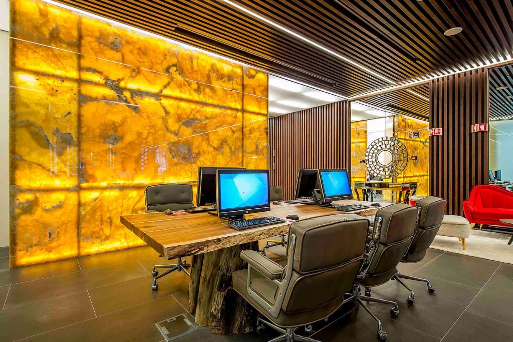 A shared business workspace with three desktop computers around a wooden table.
