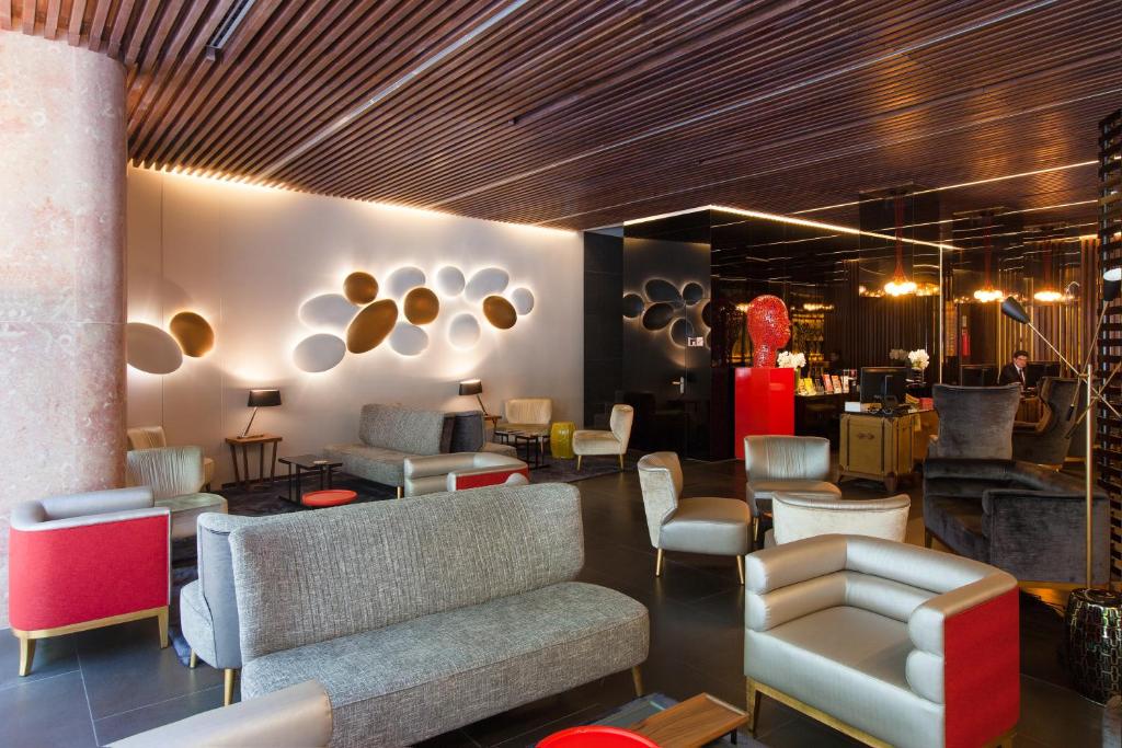 A design-focused lobby lounge with sofas, armchairs and layered lighting.