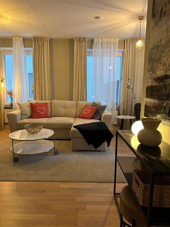 ein Wohnzimmer mit einem Sofa und einem Tisch in der Unterkunft Hagastaden flat in Stockholm