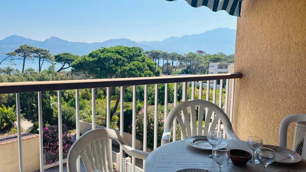 - une table avec des verres à vin au-dessus du balcon dans l'établissement Appartement 19 Les Carolines 2 Calvi, à Calvi