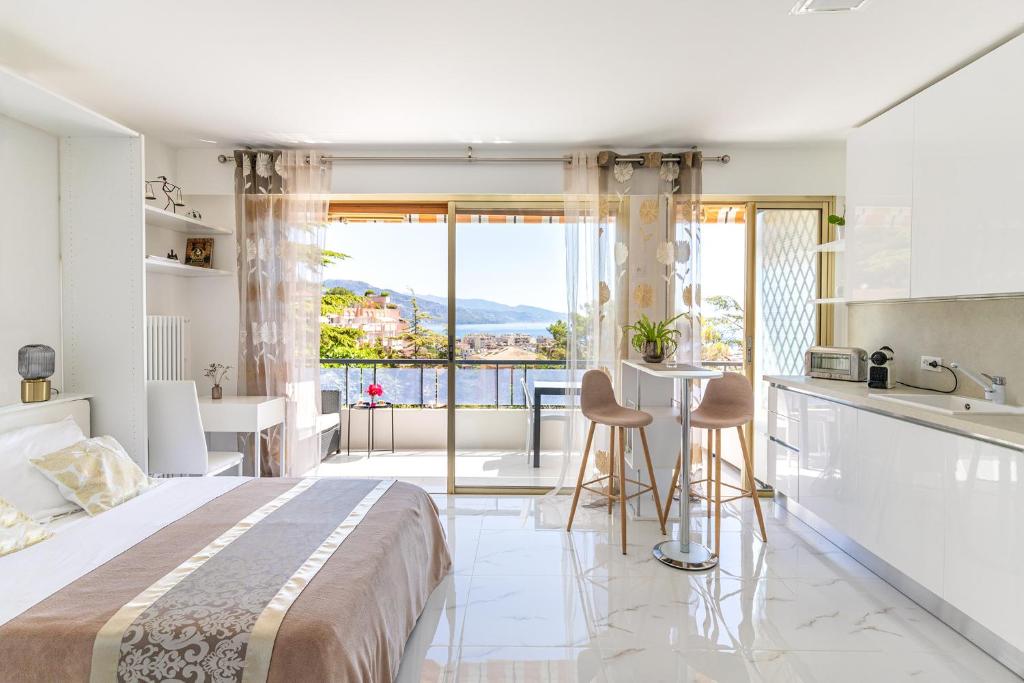 Cet appartement comprend une chambre avec un lit et une cuisine avec vue. dans l'établissement Magnifique studio limitrophe Monaco, parking privé, à Roquebrune-Cap-Martin