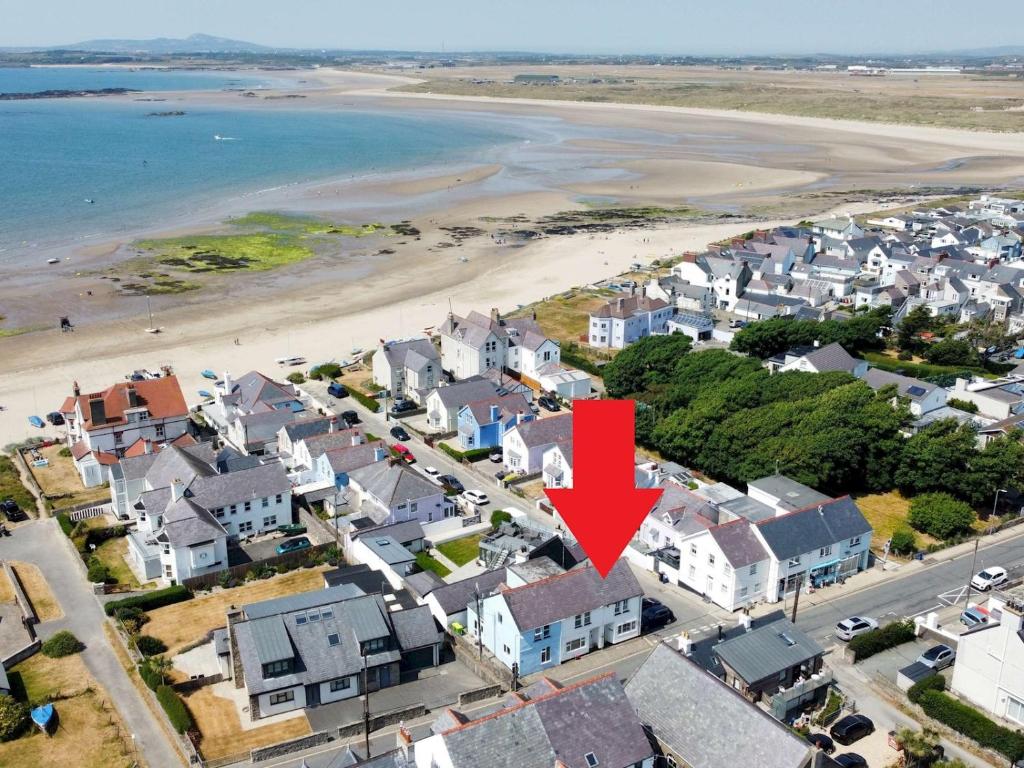 an aerial view of a coastal town with a red arrow at Pass the Keys Breeze Cottage 2 bed Beach property in Rhosneigr