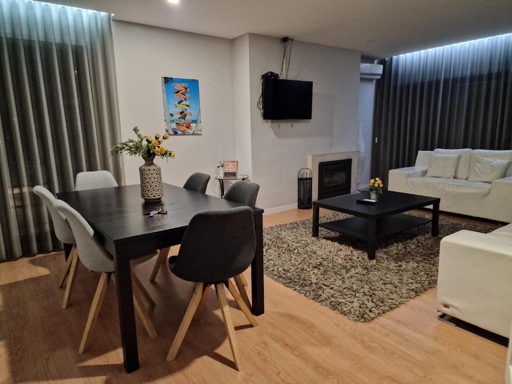 a living room with a table and chairs and a couch at Central Bus Station Flat in Braga