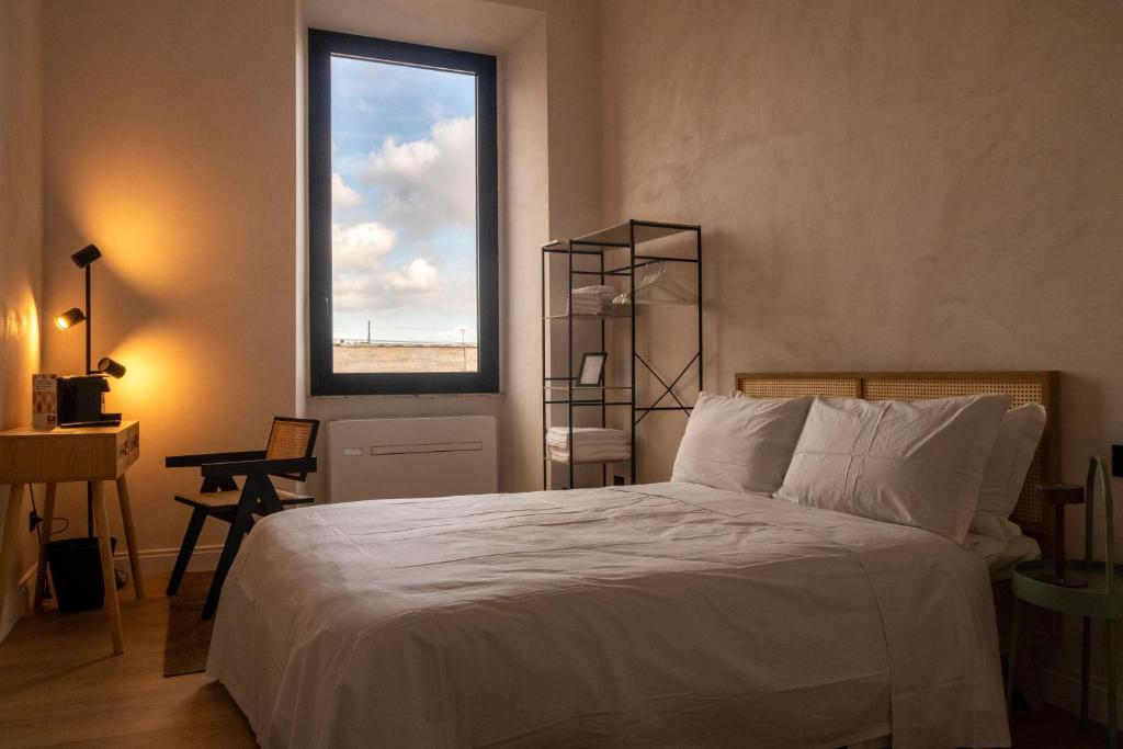 a bedroom with a white bed and a window at Cunabu Apartments in Rome