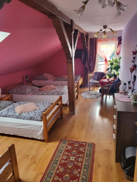a bedroom with four beds in a room with pink walls at Agroturystyka Świerki in Lubawka