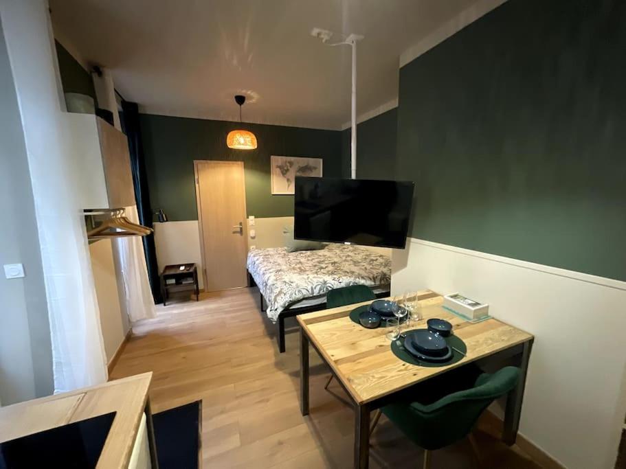 - une chambre avec un lit et une table dans l'établissement Émeraude - Centre-ville /Terrasse /Parking gratuit, à Roanne