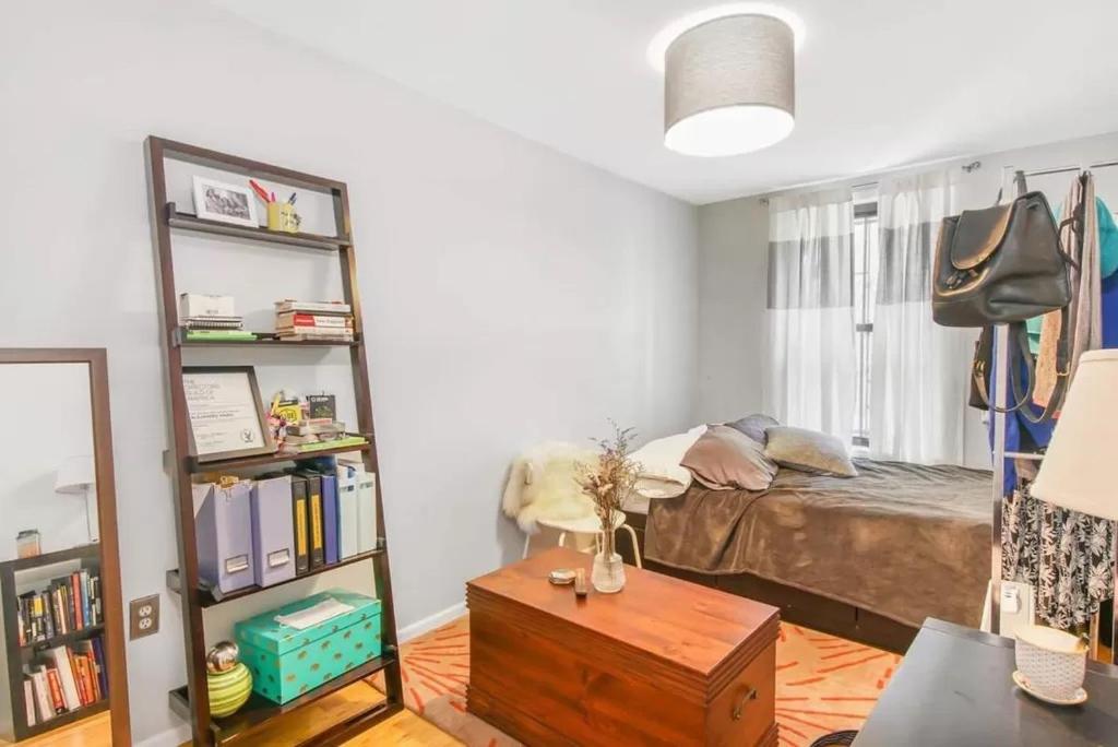 a bedroom with a bed and a book shelf at Private room in 4 bedroom Ground Apartment near Subway in Brooklyn