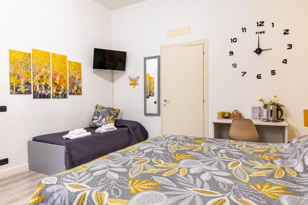 1 dormitorio con 1 cama y reloj en la pared en Sapore di mare 5 Terre Affittacamere, en La Spezia