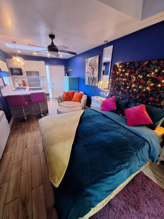 Un dormitorio con una gran cama azul con almohadas coloridas en Park House Studio en Matlock