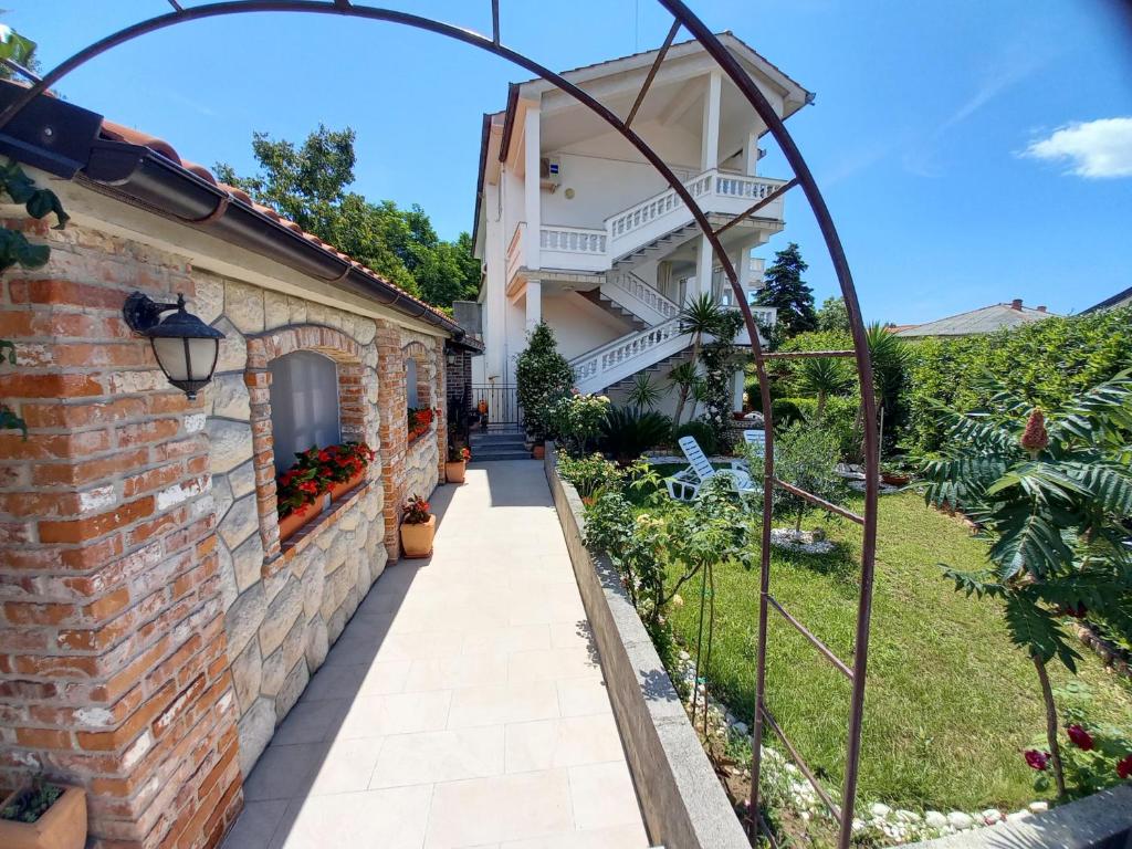 a walkway to a house with a brick wall at Apartmani Dijana in Rab