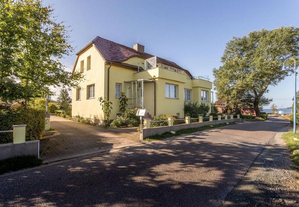 una casa amarilla al lado de una carretera en Haus Silbermöwe, en Gager