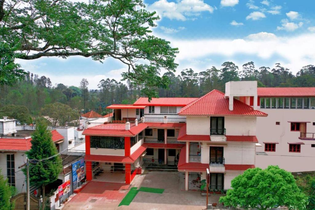 een gebouw met een rood dak in een stad bij LA FLORA SKT, YERCAUD in Yercaud