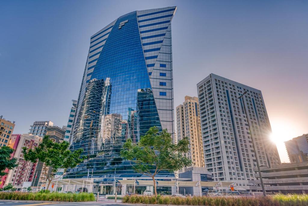 wysoki budynek w mieście z wieżowcami w obiekcie Grand Heights Hotel Apartments w Dubaju