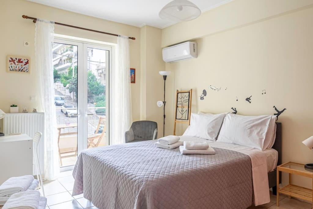 1 dormitorio con 1 cama con toallas en Positive vibes: Athens studio, en Atenas