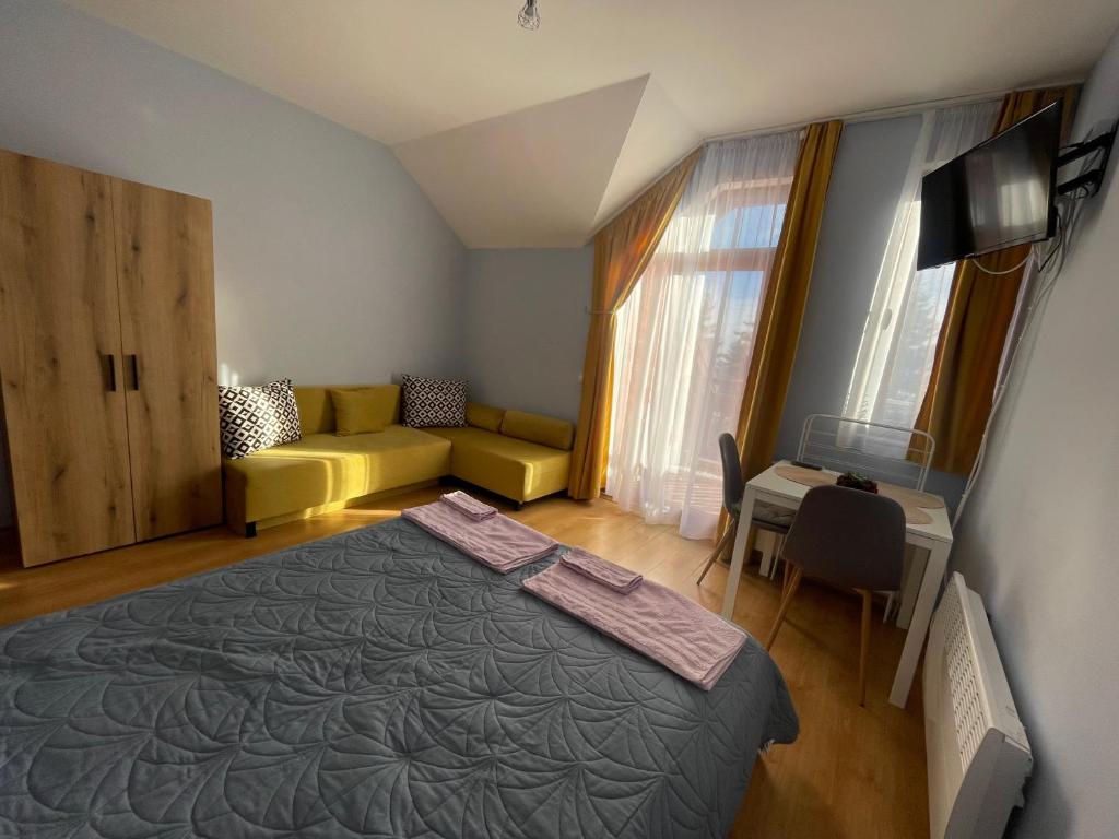 um quarto com uma cama, um sofá e uma mesa em Ваканционно жилище-Боровец em Borovets