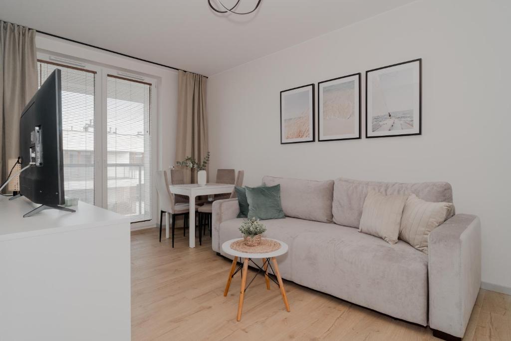 a living room with a couch and a table at TOTU HOME Perspektywa Apartament Gdańsk Centrum in Gdańsk