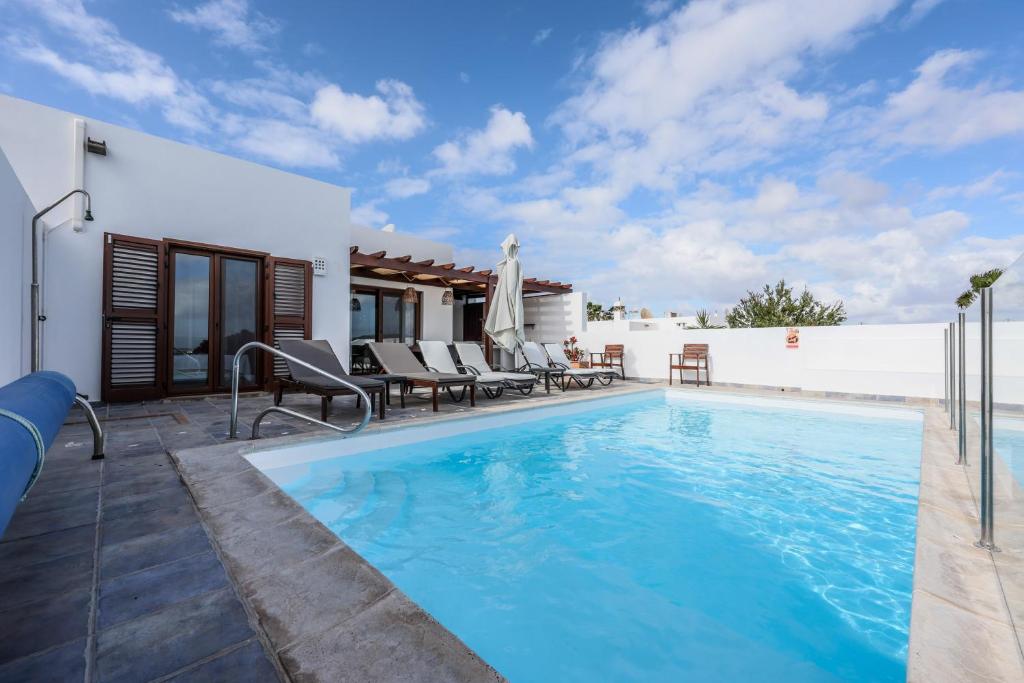 una piscina en el patio trasero de una casa en VILLAS LANZAROTE LOS ALTOS by NEW LANZASUITES Villa SERENA en Playa Blanca