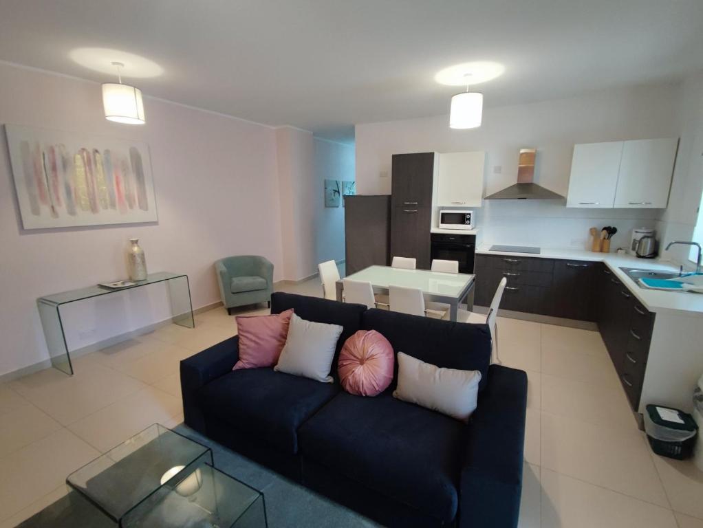 a living room with a couch and a kitchen at St Julians - Balluta 2 bedroom apartment in St Julian's