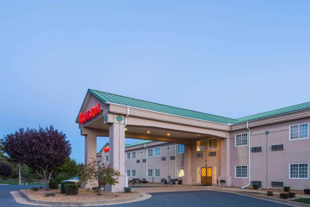 a hotel with a sign on the front of a building at Ramada by Wyndham Strasburg - Shenandoah Valley in Strasburg