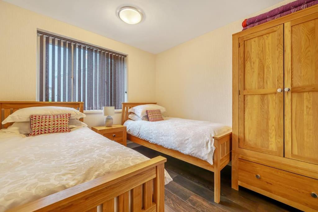 a bedroom with two beds and a large window at Modern Bowness-on-Windermere Flat - Free Parking in Bowness-on-Windermere