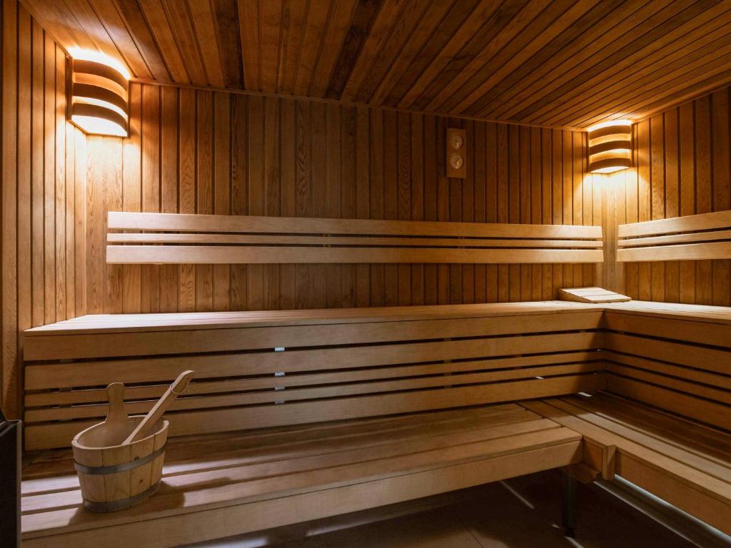 a sauna with benches and a bucket in it at Novotel Amsterdam City in Amsterdam