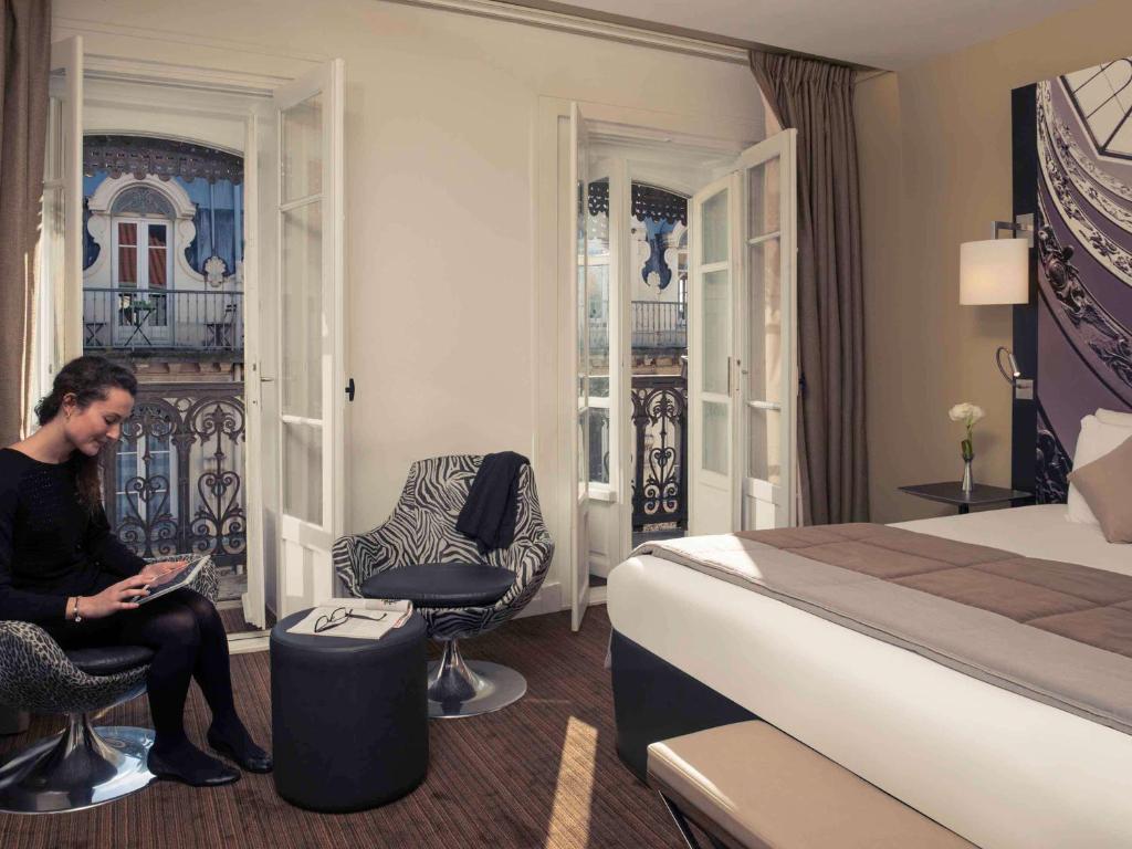 a woman sitting in a chair in a hotel room at Mercure Lyon Centre Beaux-Arts in Lyon