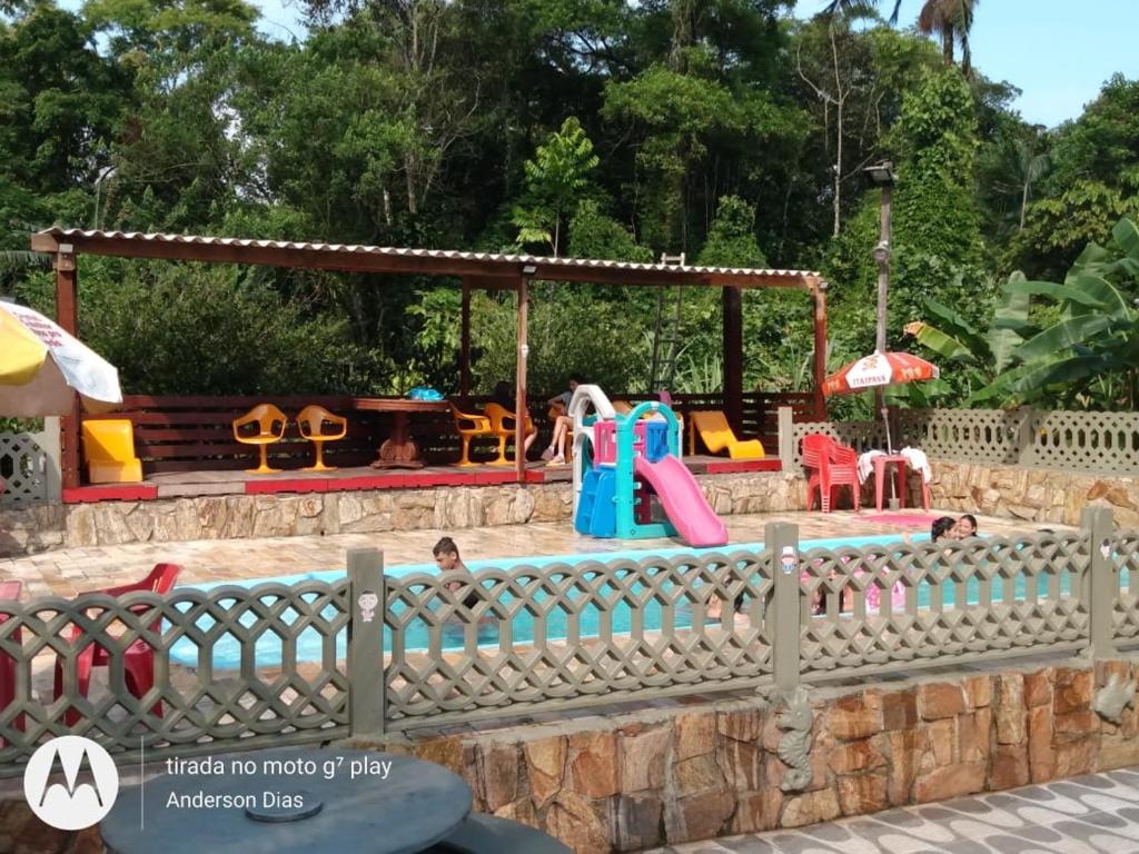 a childrens play area with a pool and a playground at Recanto do Zeca in Praia Grande