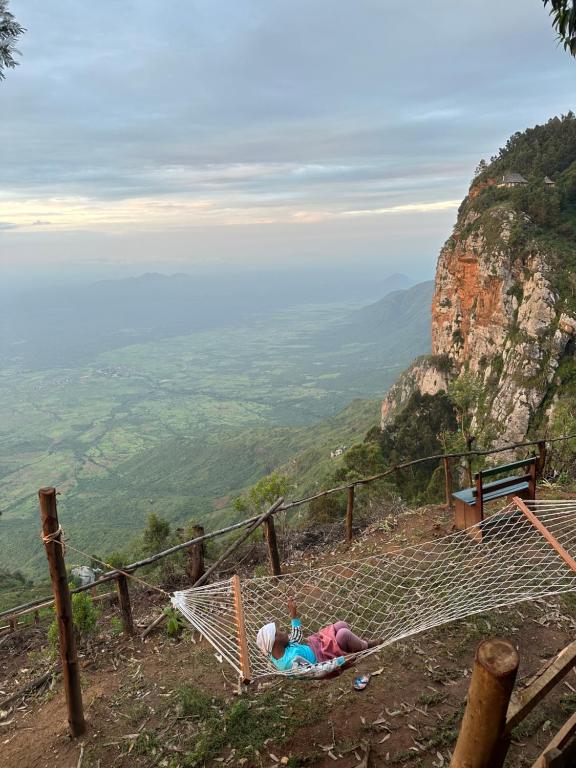 a person laying on a hammock on a mountain at Uvi House & Restaurant in Mntindili