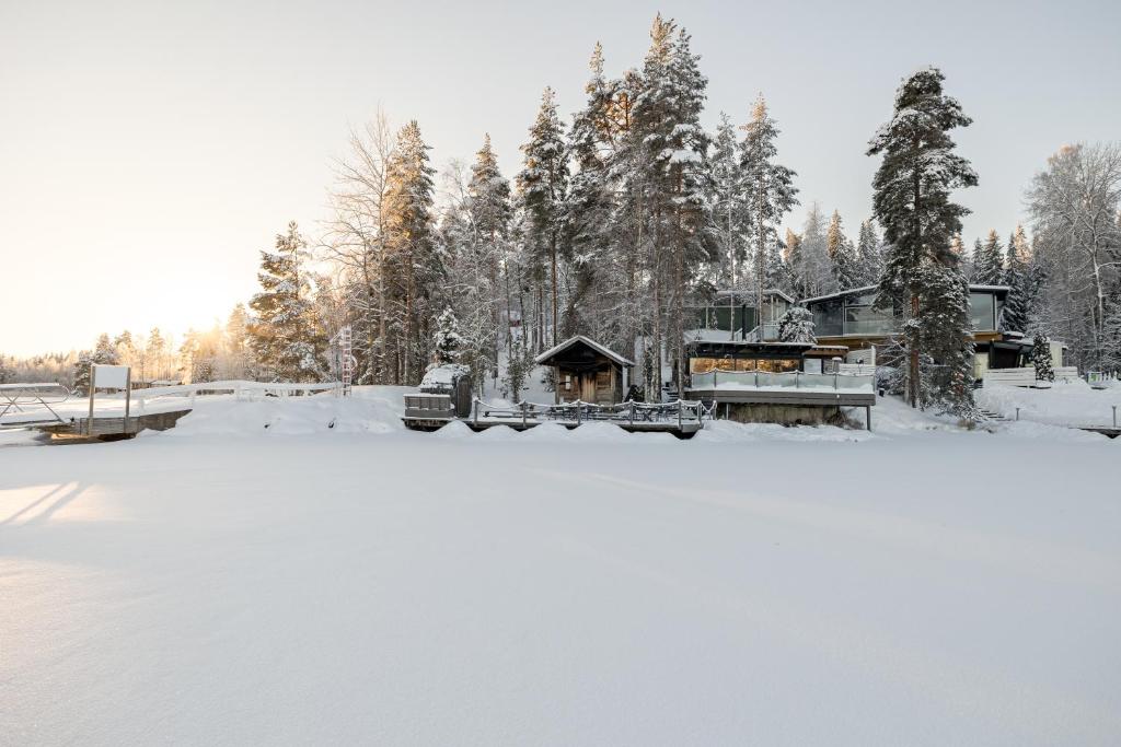una cabaña en la nieve junto a un lago congelado en Lehmonkärki Resort en Asikkala