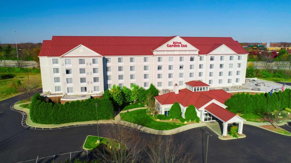a large white building with a red roof at Hilton Garden Inn Louisville-Northeast in Louisville
