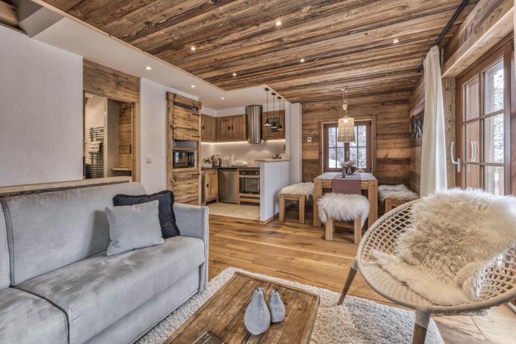 a living room with a couch and a table at Chalet 3 étoiles pour 4 pers avec vue imprenable sur la vallée de Chamonix in Les Houches