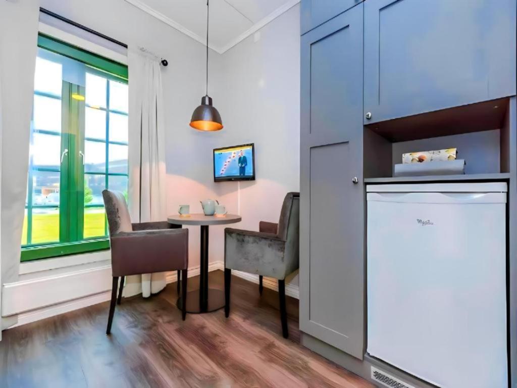 a kitchen with a small table and chairs and a window at Oslo Airport Inn in Gardermoen