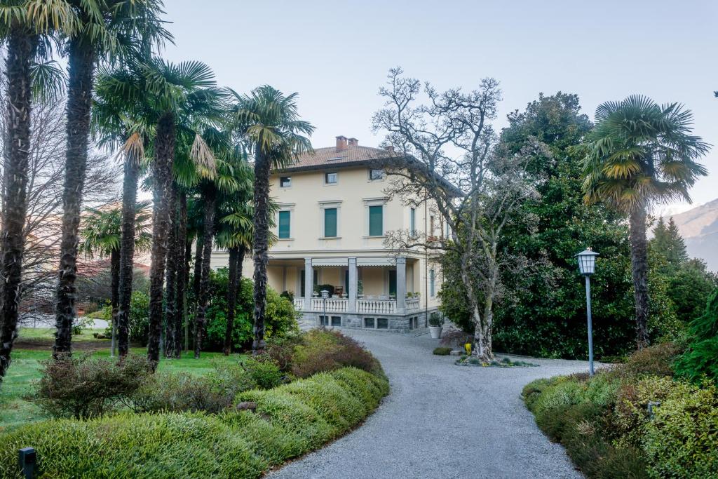 una casa con palme e un vialetto di ghiaia di Regal Villa with Como Lake View and Free Parking a Bellagio