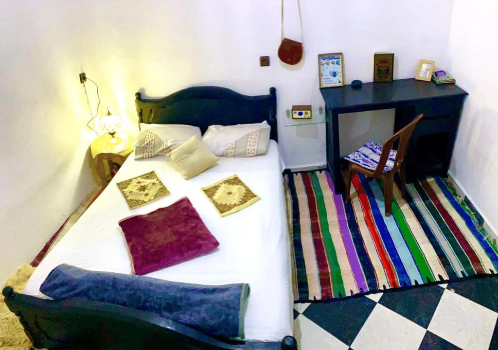 a bedroom with a bed with colorful pillows on it at Apartment in Safi near the beach the sea calm down in Safi