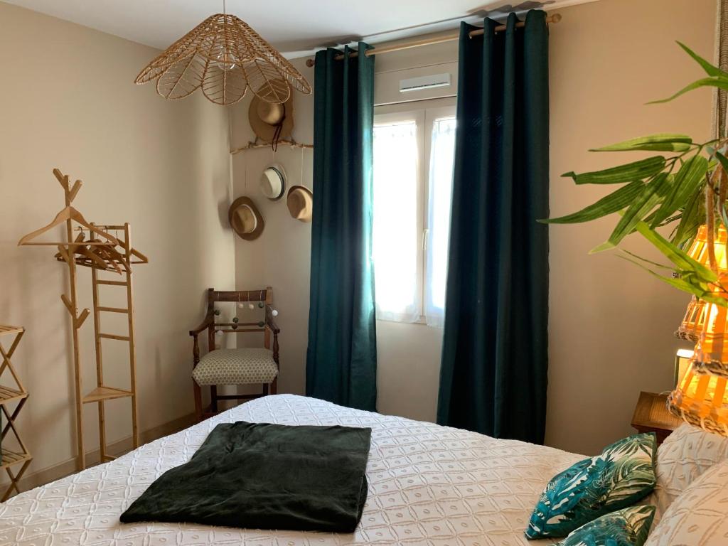 a bedroom with a bed with blue curtains and a window at Gite de Groupe Aux Instants Partagés in Fontenay-sur-Vègre