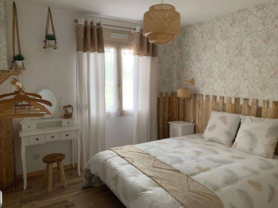 a bedroom with a bed and a desk and a window at Gite de Groupe Aux Instants Partagés in Fontenay-sur-Vègre